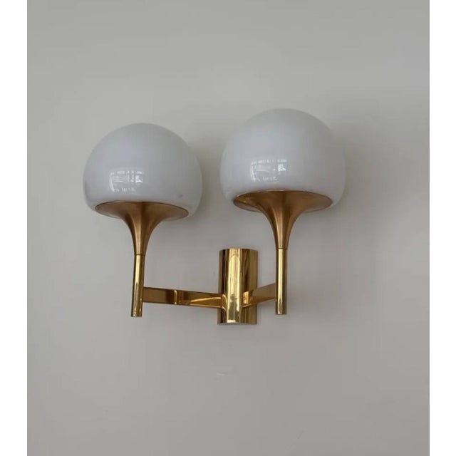 Gold-plated metal and opaline wall lights, 1970. Perfect condition. Pair available. Up to 250V (Europe/UK Standard).The...
