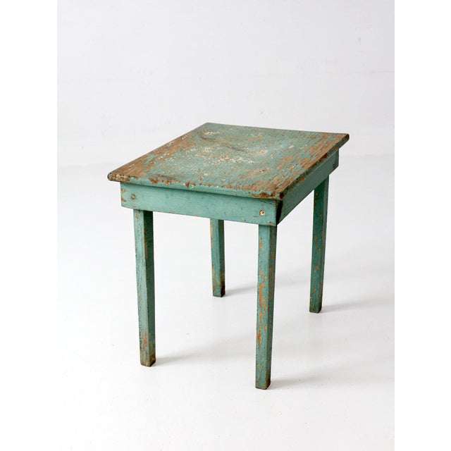 This early 20th century Primitive painted side table features a beautifully weathered turquoise surface with layers of...