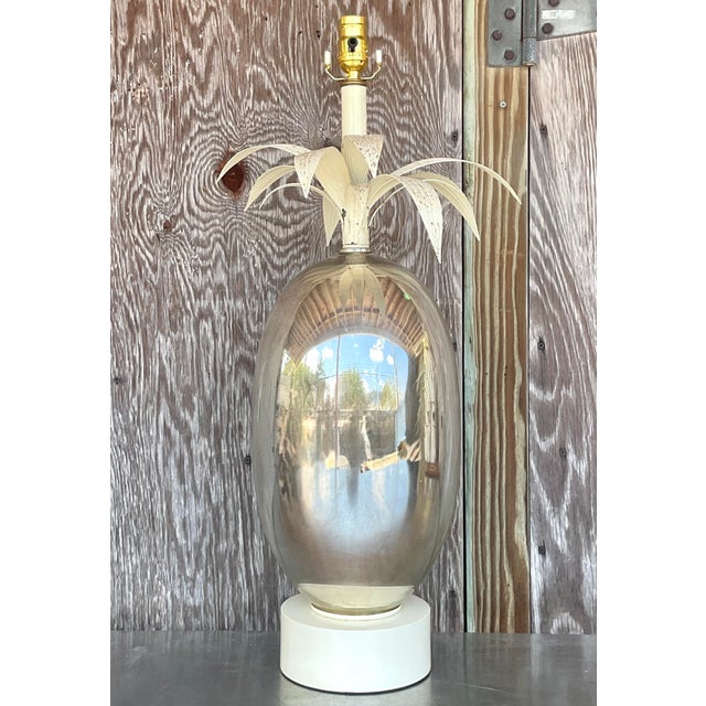 Channel breezy, coastal sophistication with this striking vintage mercury glass lamp topped with sculptural palm fronds....