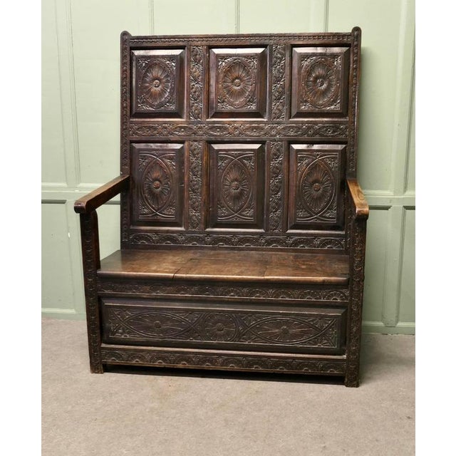 The Settle has a superbly carved high panelled back with 8 panels carved in a Celtic design with the sun at the centre...