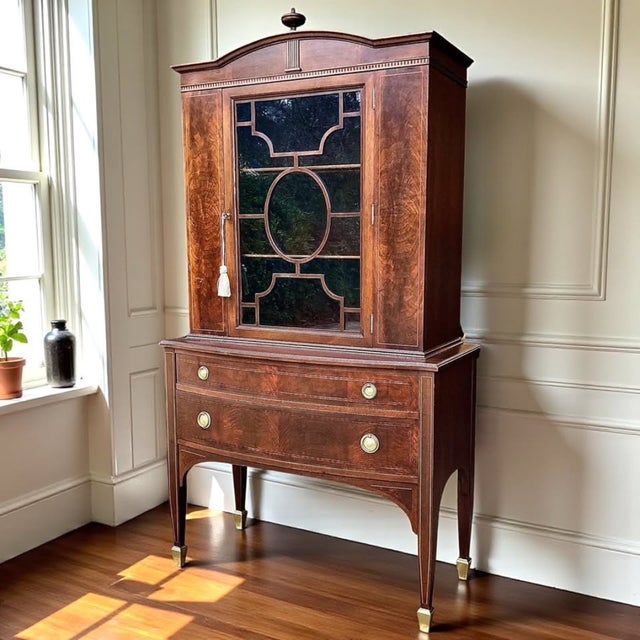This striking 1930s Federal Revival cabinet pairs exceptional bookmatched crotch mahogany with richly feathered walnut...