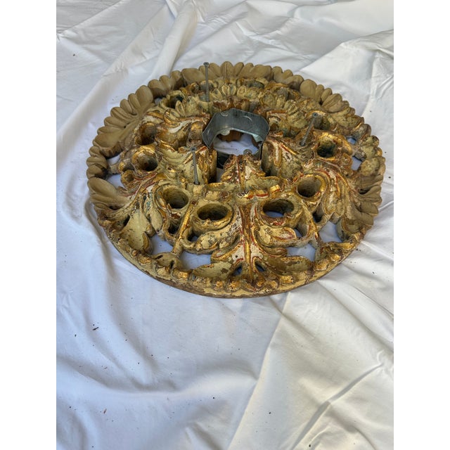 Round pierced acanthus-leaf ceiling rosette in carved wood with distressed gilt.