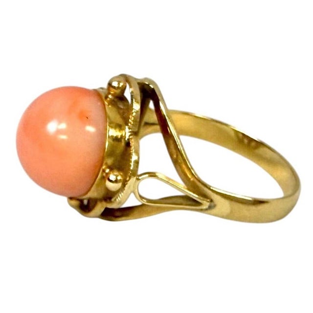 18K Gold and Angel Skin Coral Cabochon Ring, distinguished by its warm blush-coral colored cabochon and graceful openwork...