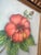 This vintage piece is an original floral watercolor painting on textured paper, featuring a vibrant red hibiscus blossom...