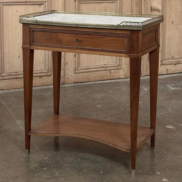 Distinguished by its elongated rectangular form and generous proportions, this French Louis XVI side table offers both...