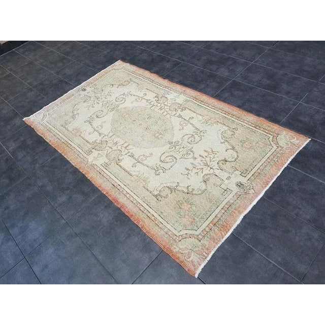 This is a vintage Turkish Oushak rug from the 1960s. The piece was hand-knotted.