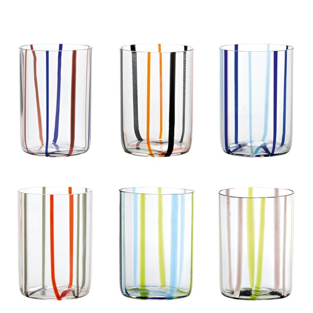 Clear glass tumblers and accessories. From the bottom of the glass, lines of alternating colors curl upwards like two-tone...