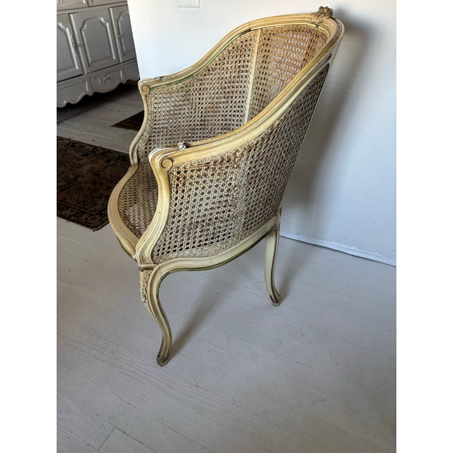 Elegant vintage French Louis XV style barrel back armchair featuring exquisite woven cane detailing and a beautifully...