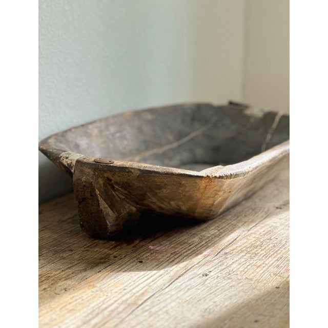 An evocative antique wooden dough trough featuring a beautifully weathered surface, sculptural elongated proportions, and...