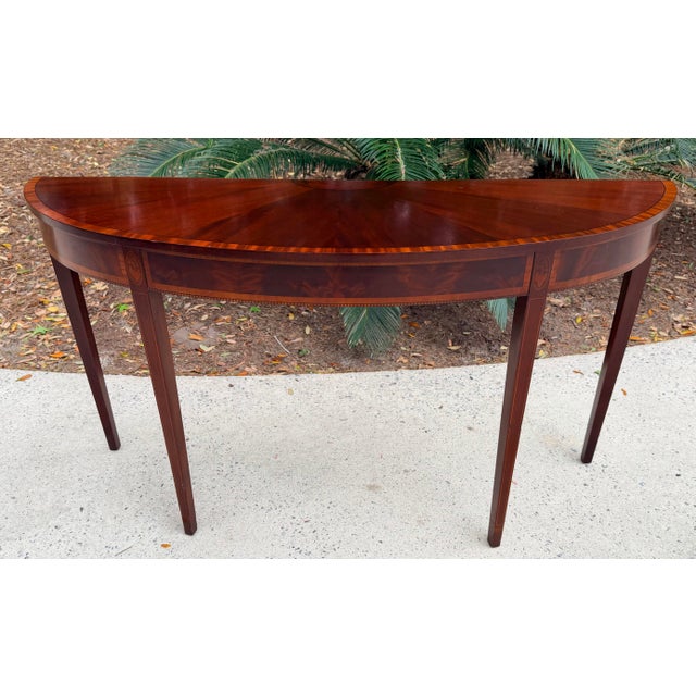 This is an elegant Federal style mahogany console table with sunburst top and banded edge. The apron is a flame mahogany...