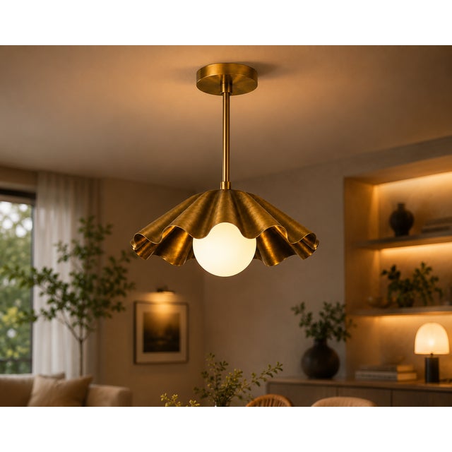 Crafted from solid brass, this handcrafted scalloped pendant light features a flowing brass shade surrounding a softly...
