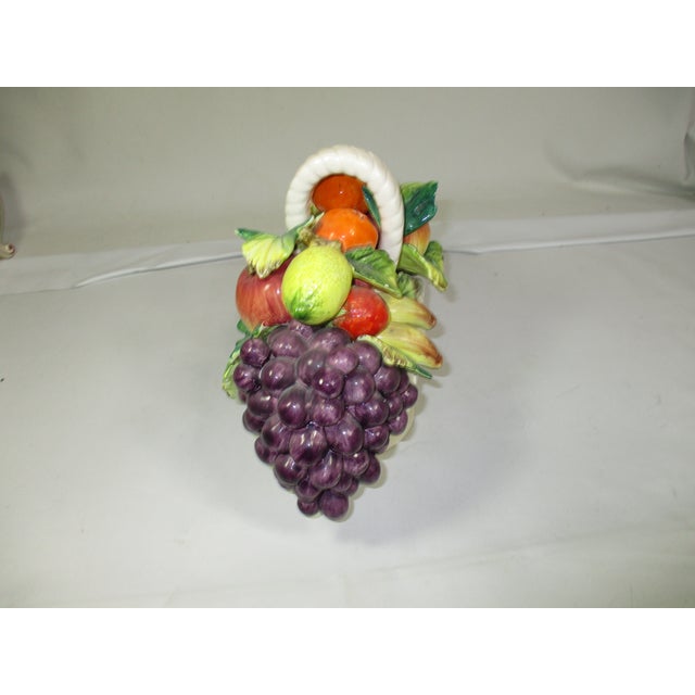 This is a vintage Capodimonte hand-crafted ceramic basket overflowing with various types of hand painted fruit. It is made...