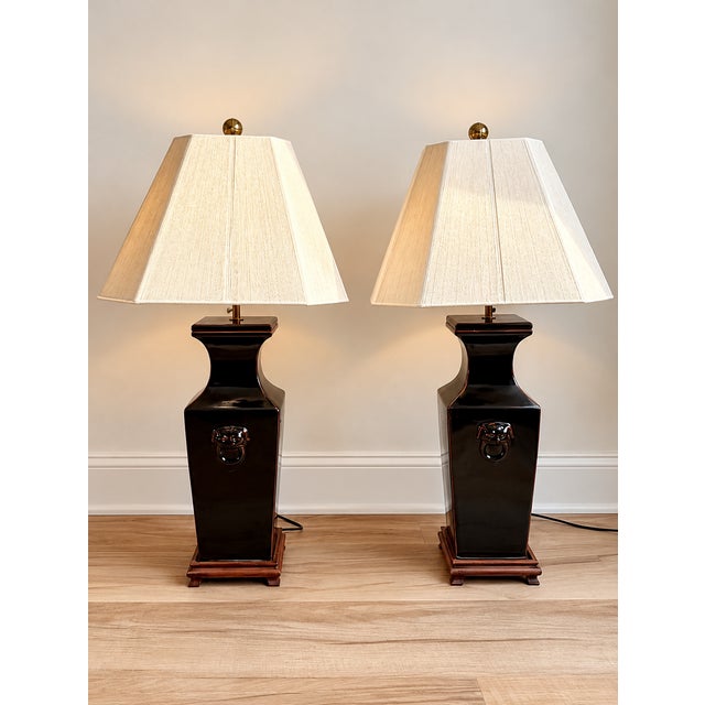 Striking pair of oversized vintage Asian-style table lamps featuring glossy black-brown glazed ceramic bodies with...