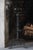 A pair of ornate and massive Gothic Revival style wrought iron andirons with torch finials, acanthus leaf detailing, rope-...