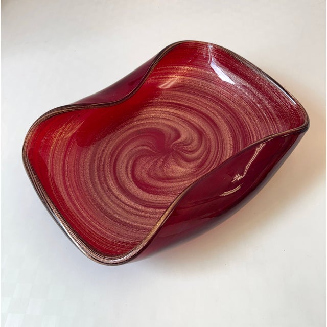 A stunning large deep red Murano style glass bowl with gold leaf flecks swirled throughout and curved sides. A standout...
