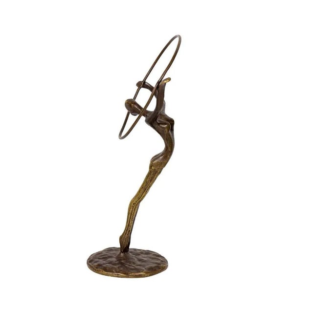 A beautiful sculpture in bronze with original patina showing a figure of a hoop dancer performing a very flexible...