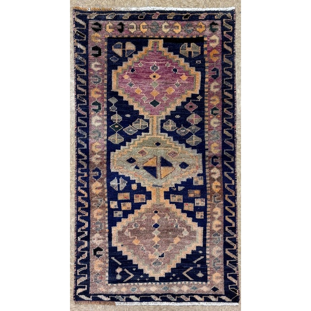 Hand-knotted tribal rug from the Luri tribes of western Iran, featuring three large geometric medallions aligned along the...