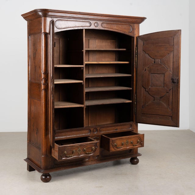 Late 18th century French armoire, crafted in oak with substantial decorative paneled doors and a simple rounded crown....