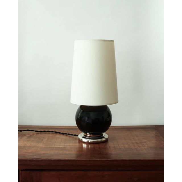 Spherical table lamp in black glazed ceramic, resting on a chrome base. French work from the 1930s, in the style of...