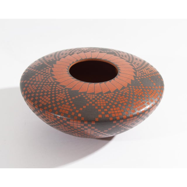 A Mata Ortiz pottery vessel by Mexican artist Luis Rodriguez. This vessel features a checkered pattern on the majority of...