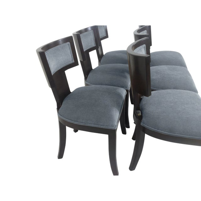 Modern set of Klismos style dining chairs. The set has a dark expresso finish on wood. The chairs are done in a rich blue...