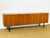 A low teak sideboard with a scandinavian modernist design from the 1960s. featuring a fine, even grain that highlights the...