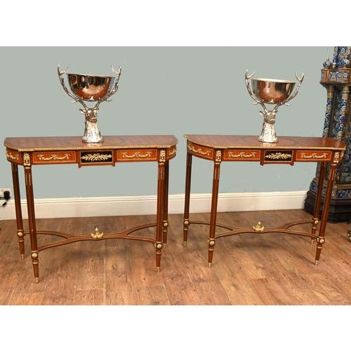 A superb pair of antique french gilt-mounted console tables in the louis xvi style, crafted in finely figured mahogany...