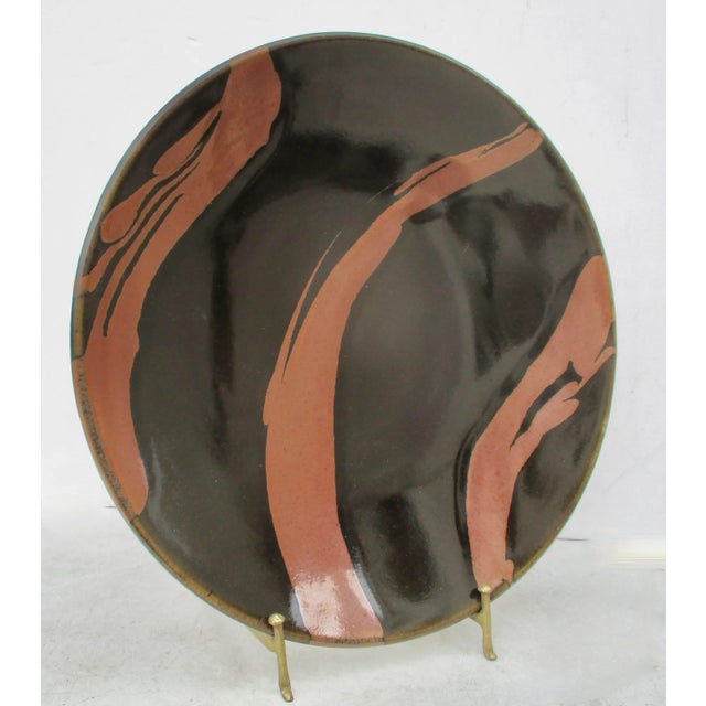 Smart design in black and brown stripes. Heavy stoneware deep charger with a bold brown brush across a jet-black field....