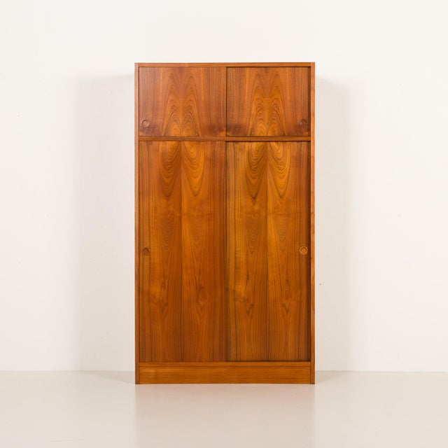 This danish mid-century teak wardrobe was designed by poul hundevad and made by hundevad in the 1960s. It features the...