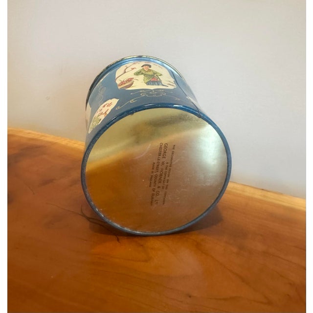 A charming vintage tole tea canister featuring a rich cobalt blue ground adorned with delicate hand-painted Chinoiserie...