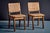 A rare pair of French dining chairs from the 1950s. The solid wooden frames show a clear architectural structure, with...