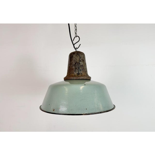 Industrial petrol enamel pendant light made in Poland during the 1960s. White enamel inside the shade. Cast iron top. The...