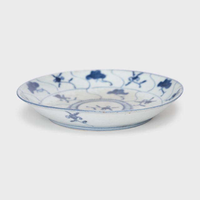 This 19th-century porcelain plate is hand-painted with cobalt underglaze in the blue-and-white manner, loosely brushed...