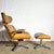 This mid-century modern Eames-style lounge chair and ottoman feature sculpted bentwood shells, supple tufted faux leather...