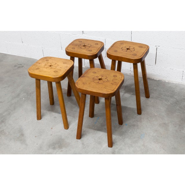Set of four handcrafted, Brutalist-style stools from the 1960s, each featuring a carved flower on the top. These four...