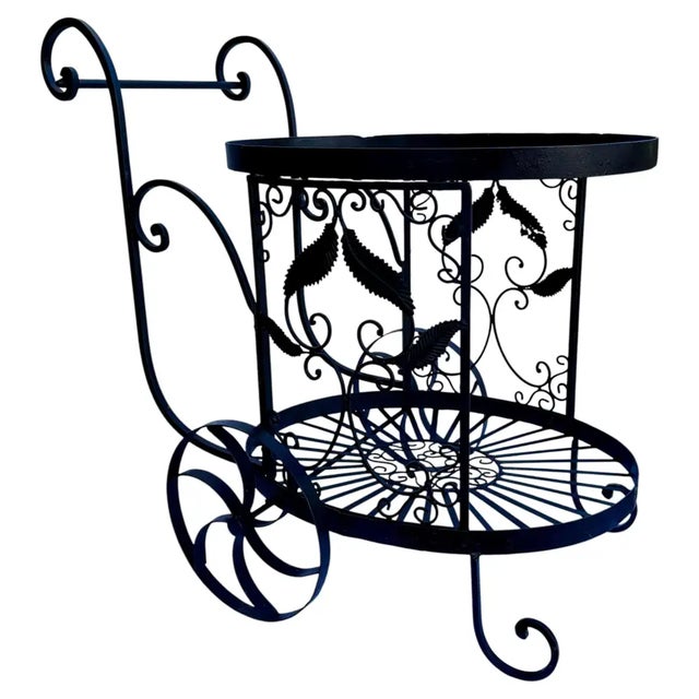 A striking example of vintage decorative ironwork, this stationary two‑tier console table is crafted in black wrought iron...