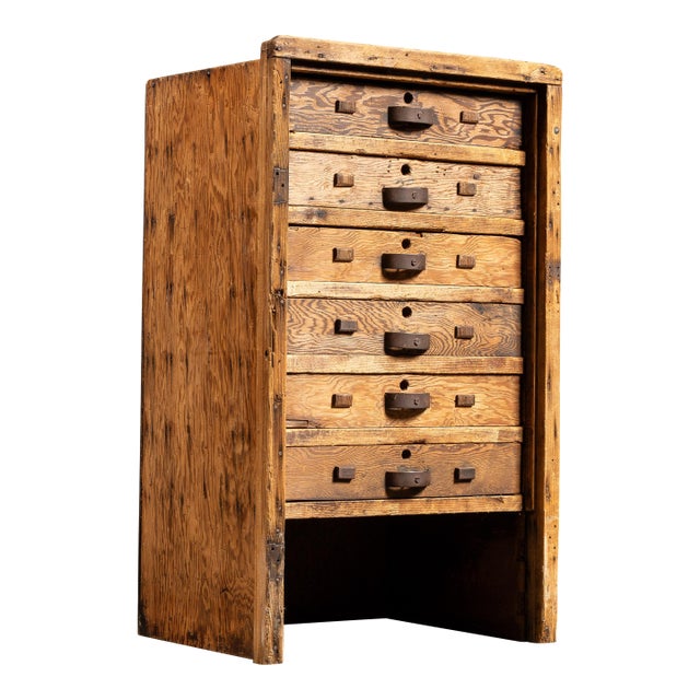 Hand-built wooden drawer cabinet constructed with a straightforward, utilitarian approach, emphasizing function over...