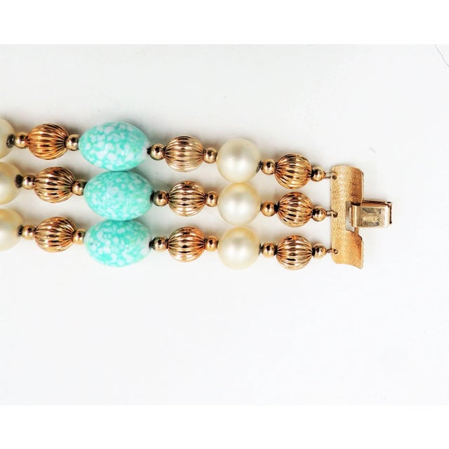 1960s goldtone resin faux-pearls and faux-turquoise speckled beads with fold over clasp. Marked "Napier." Measures: 8.25...
