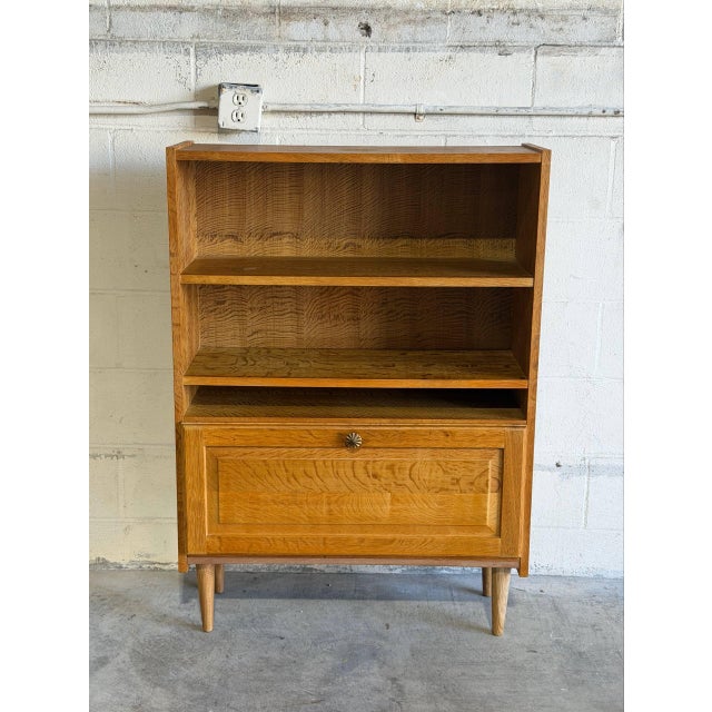 This versatile storage piece features open shelves above a drop-down compartment door. Its clean lines and functional...