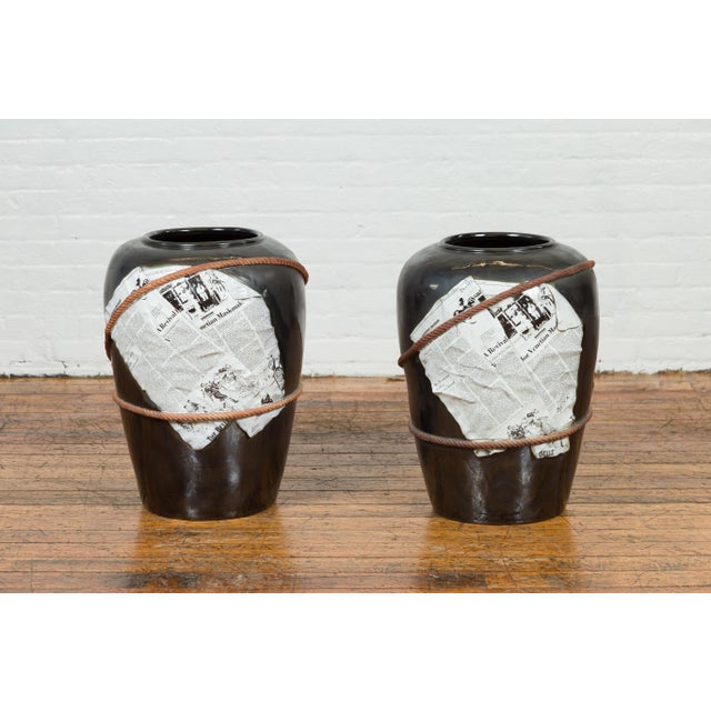 A large exterior flower vase or planter with black patina, rope and newspaper motifs, two available priced and sold...