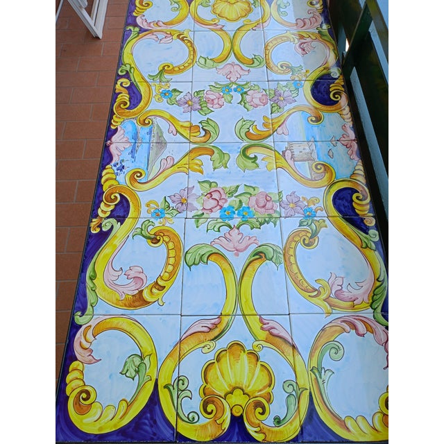 Handcrafted coffee table with a hand-painted majolica ceramic top and an ornate wrought iron base. A one-of-a-kind piece...
