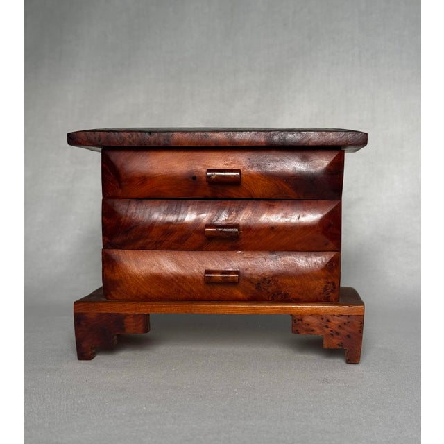 This small decorative box features a beautiful, highly polished grain with three stacked, fixed drawers and an overhanging...