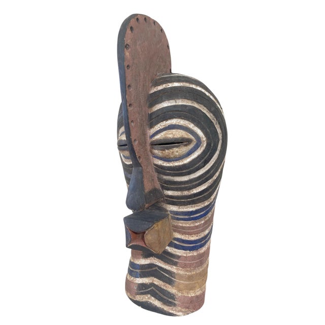 This stunning large Songye Kifwebe Mask hails from DR Congo and has a height of 27.5", a width of 12", and a depth of 9"....