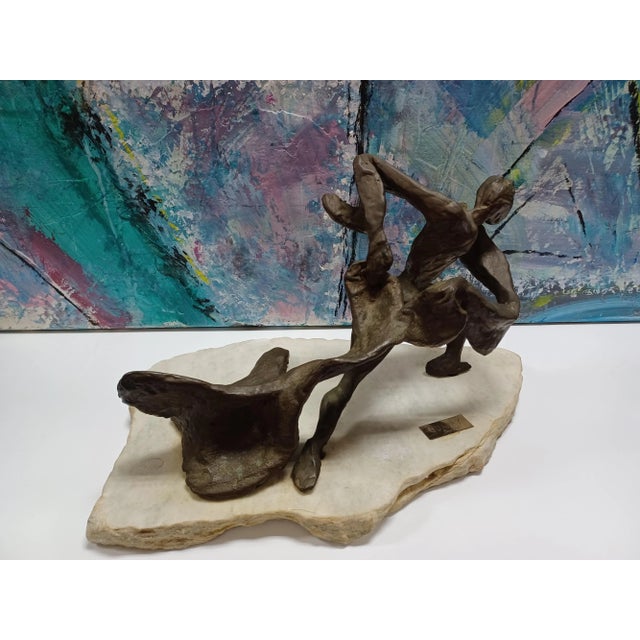 Vintage metal abstract sculpture on top of marble base. The sculpture depicts of a figure pulling something across the...
