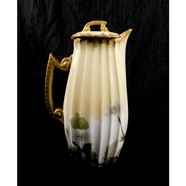 This is a Tressemanes & Vogt Limoges Chocolate pot in an unknown pattern. The chocolate pot is ridged in a beige color...