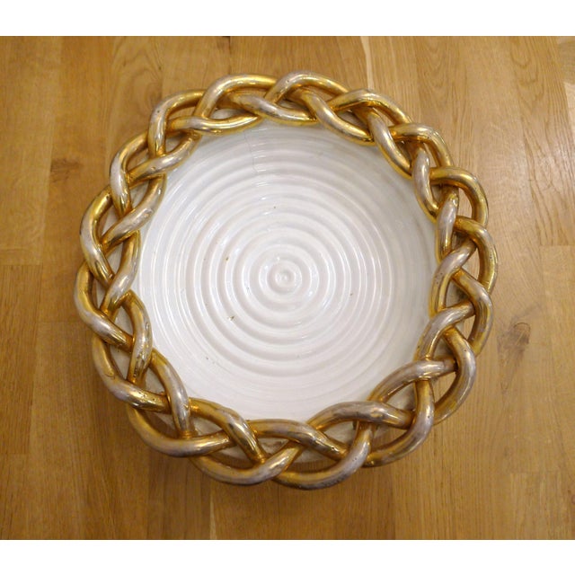 Woven basket/dish; round shape, raised woven base, container made with coils (raised coiled rings), and wide openwork...
