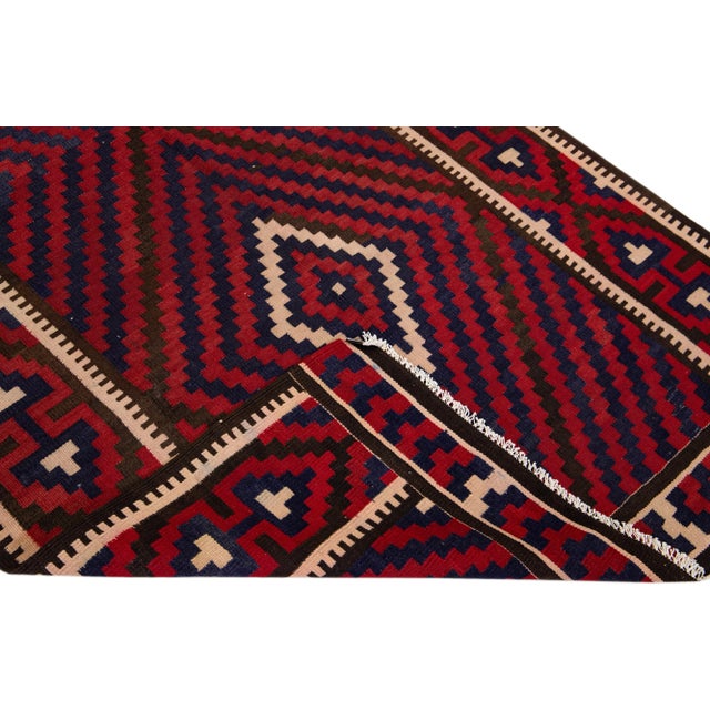 Beautiful vintage Turkish Kilim hand-knotted wool rug with a red field. This piece has a red frame and multicolor accents...