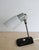 The lamp features an elegant black ceramic base manufactured by Ditmar Urbach, a slender steel stem, and an original milk-...