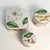 A coordinated set of three Tiffany & Co. “Tiffany Flowers” lidded trinket boxes in Limoges porcelain, made in France....
