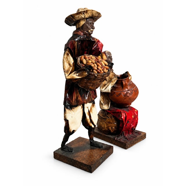 A characterful pair of vintage Mexican folk art market figures. The standing man wears a broad hat and carries a woven...